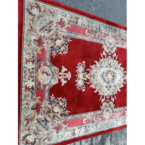 88A - A red floral pattern rug - approx. 280cm x 183cm