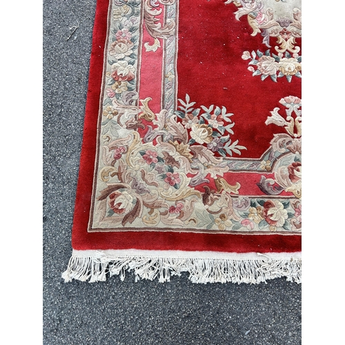 88A - A red floral pattern rug - approx. 280cm x 183cm