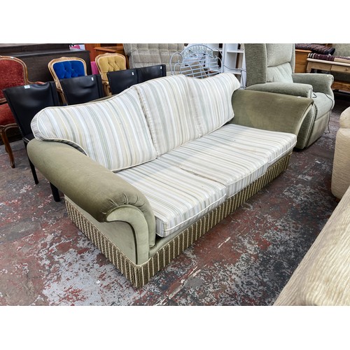 251 - A late 20th century green fabric upholstered and tasselled three seater sofa