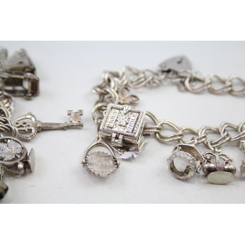 2111 - Two silver charm bracelets with assorted charms - approx. gross weight 85g