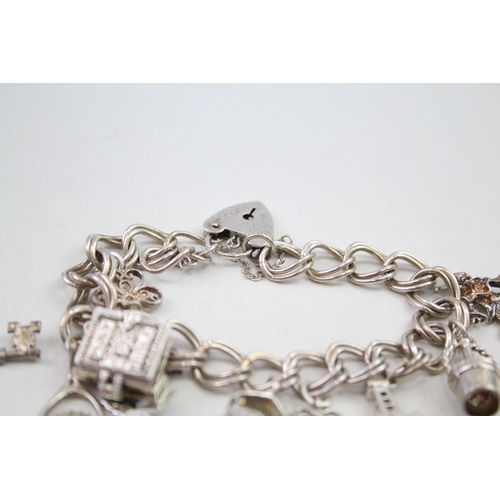 2111 - Two silver charm bracelets with assorted charms - approx. gross weight 85g