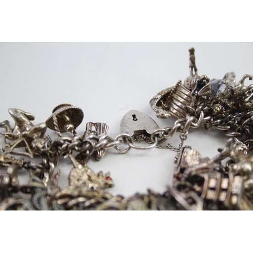 2152 - A hallmarked .925 silver charm bracelet with assorted charms - approx. gross weight 150g