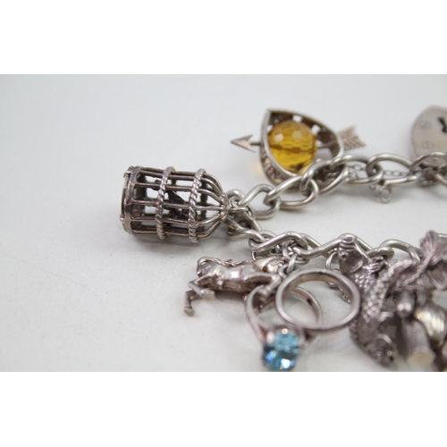 2164 - A silver charm bracelet with assorted charms - approx. gross weight 64g