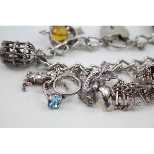 2164 - A silver charm bracelet with assorted charms - approx. gross weight 64g