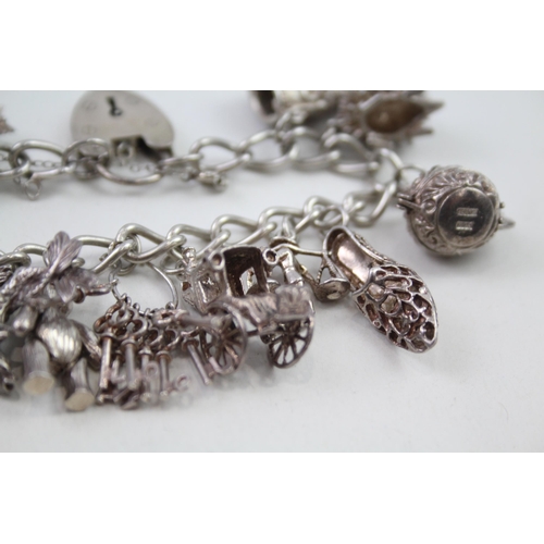 2164 - A silver charm bracelet with assorted charms - approx. gross weight 64g