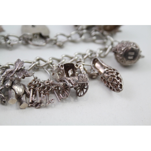 2164 - A silver charm bracelet with assorted charms - approx. gross weight 64g