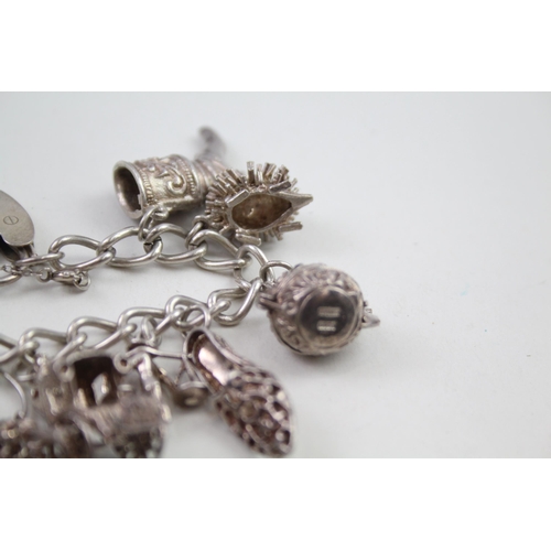 2164 - A silver charm bracelet with assorted charms - approx. gross weight 64g