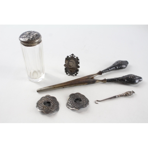 2195 - Six pieces of .925 sterling silver to include glove stretchers, miniature photo frame, button hook e... 