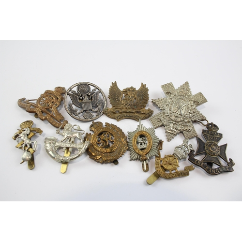 2304 - A collection of vintage military cap badges