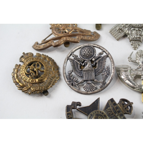 2304 - A collection of vintage military cap badges