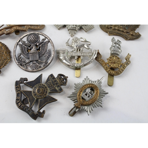 2304 - A collection of vintage military cap badges