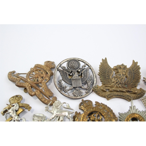 2304 - A collection of vintage military cap badges