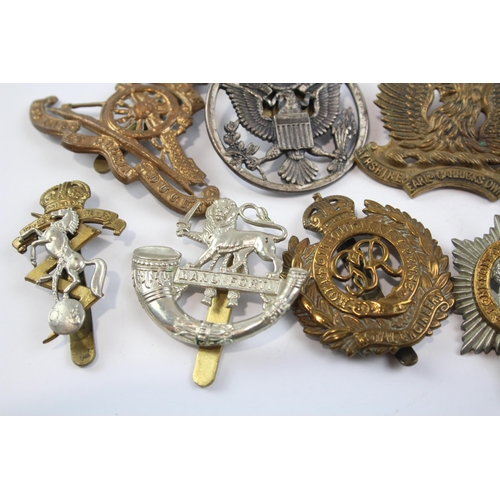 2304 - A collection of vintage military cap badges