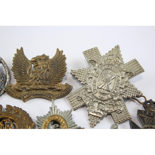 2304 - A collection of vintage military cap badges