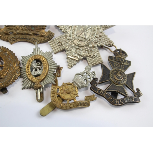 2304 - A collection of vintage military cap badges