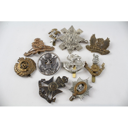 2304 - A collection of vintage military cap badges