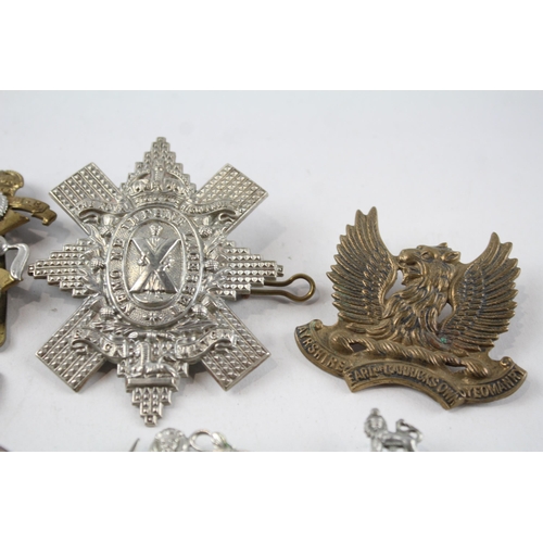 2304 - A collection of vintage military cap badges