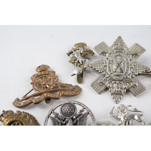 2304 - A collection of vintage military cap badges