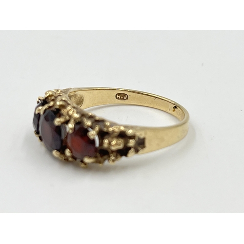 2061 - A mid 20th century Brutalist hallmarked London 9ct gold garnet trilogy ring, dated 1976 and size P -... 