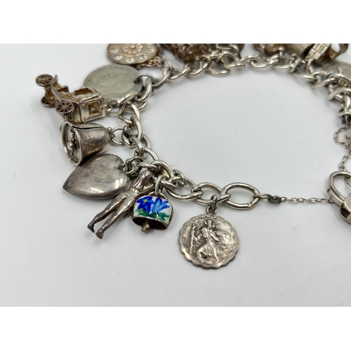 2065 - A hallmarked sterling silver charm bracelet with assorted charms - approx. gross weight 60g