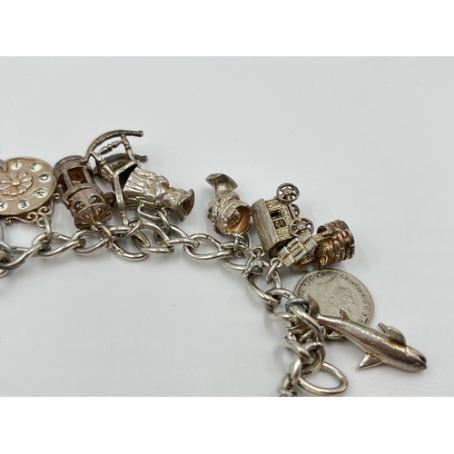 2065 - A hallmarked sterling silver charm bracelet with assorted charms - approx. gross weight 60g