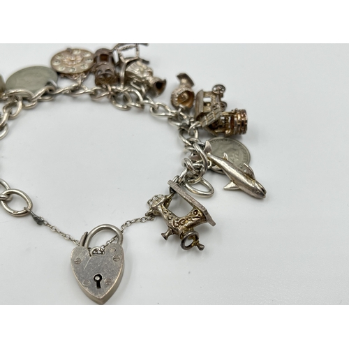 2065 - A hallmarked sterling silver charm bracelet with assorted charms - approx. gross weight 60g