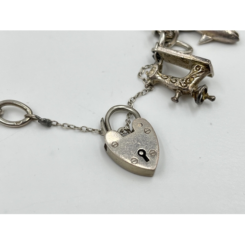 2065 - A hallmarked sterling silver charm bracelet with assorted charms - approx. gross weight 60g