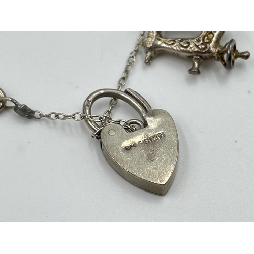 2065 - A hallmarked sterling silver charm bracelet with assorted charms - approx. gross weight 60g