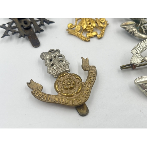 2239 - Ten military cap badges to include Loyal North Lancashire, East Lancashire, Canada, The Royal Sussex... 