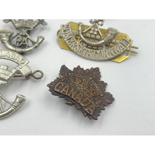 2239 - Ten military cap badges to include Loyal North Lancashire, East Lancashire, Canada, The Royal Sussex... 