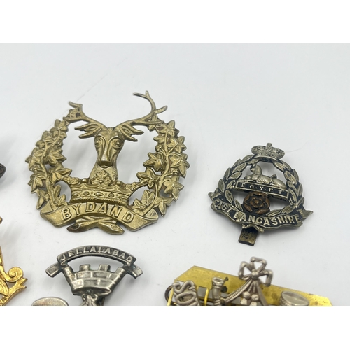 2239 - Ten military cap badges to include Loyal North Lancashire, East Lancashire, Canada, The Royal Sussex... 