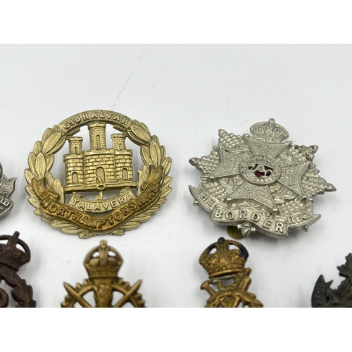 2248 - Ten military cap badges to include East Surrey, Northamptonshire, The Border Regiment, The Yorkshire... 