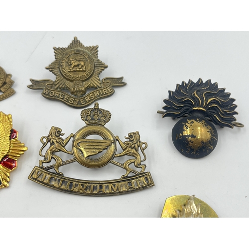 2251 - Ten military cap badges to include Worcestershire, Royal Army Ordnance Corps etc.