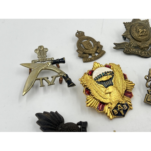 2251 - Ten military cap badges to include Worcestershire, Royal Army Ordnance Corps etc.