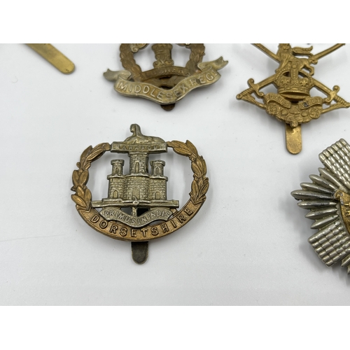 2260 - Ten military cap badges to include Middlesex Regiment, The Royal Scots, Dorsetshire etc.