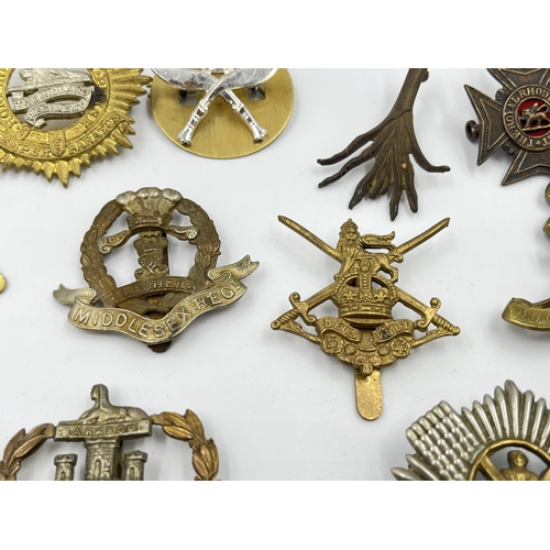 2260 - Ten military cap badges to include Middlesex Regiment, The Royal Scots, Dorsetshire etc.