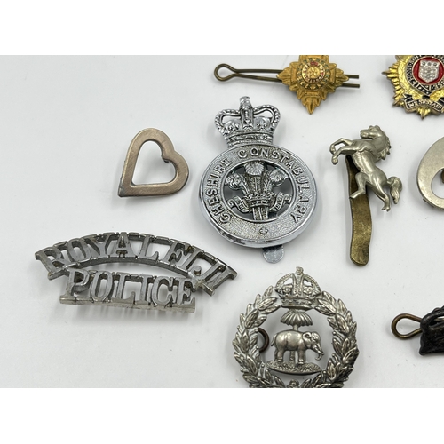 2261 - A collection of military and police cap badges to include Royal Fiji Police, Royal Kent West, Cheshi... 