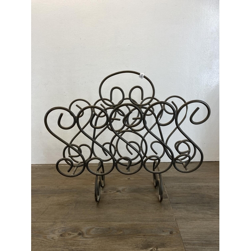 463 - Two pieces of metalware, one wrought iron two section magazine rack and a pair of 19th century cast ... 