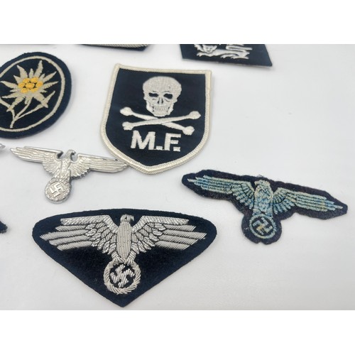 2308 - A collection of reproduction German military badges and cloth patches