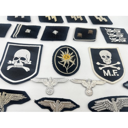 2308 - A collection of reproduction German military badges and cloth patches