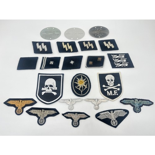 2308 - A collection of reproduction German military badges and cloth patches