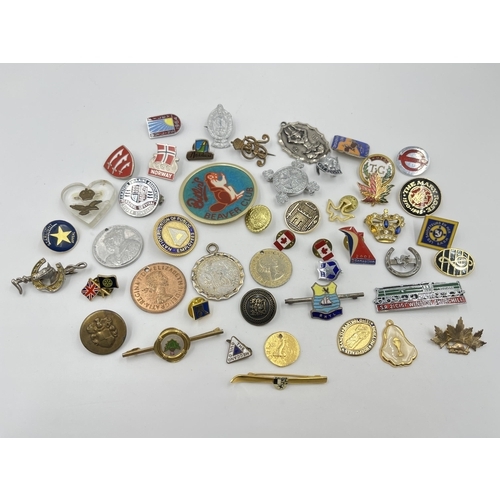 2095 - A collection of badges and buttons to include RAF, Butlins etc.