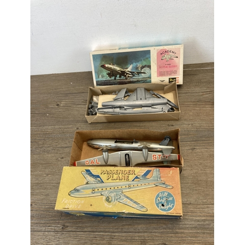 580 - Four vintage model vehicles to include boxed friction drive tin plate passenger plane, tin plate pas... 