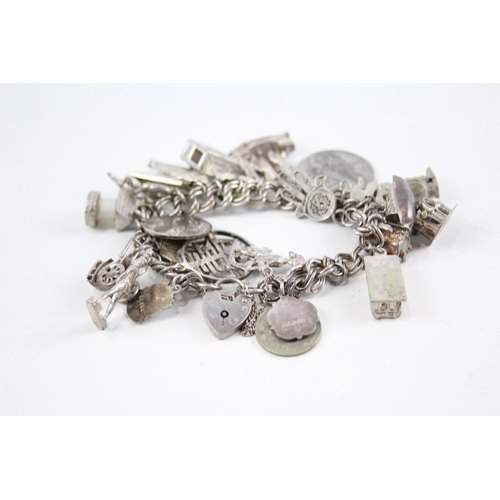 2047 - A silver charm bracelet with assorted charms - approx. gross weight 77g