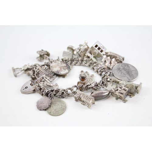 2047 - A silver charm bracelet with assorted charms - approx. gross weight 77g