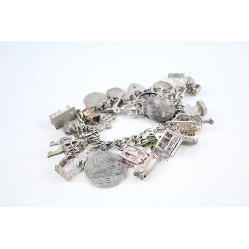 2047 - A silver charm bracelet with assorted charms - approx. gross weight 77g