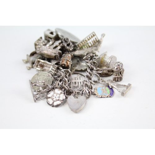 2047 - A silver charm bracelet with assorted charms - approx. gross weight 77g