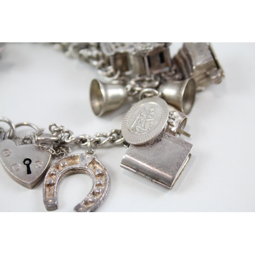 2061 - A silver charm bracelet with assorted charms - approx. gross weight 82g