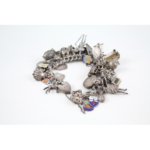 2072 - A silver charm bracelet with enamel souvenir charms - approx. gross weight 126g