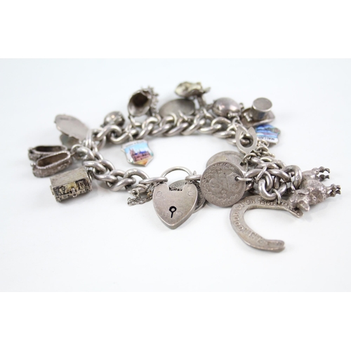 2077 - A silver charm bracelet with assorted charms - approx. gross weight 93g